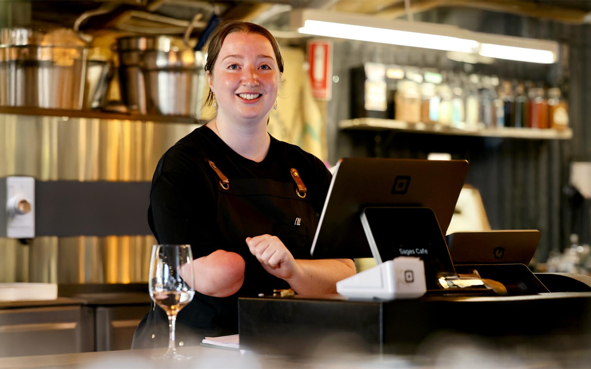 A Wallara staff participant smiling at a café counter.