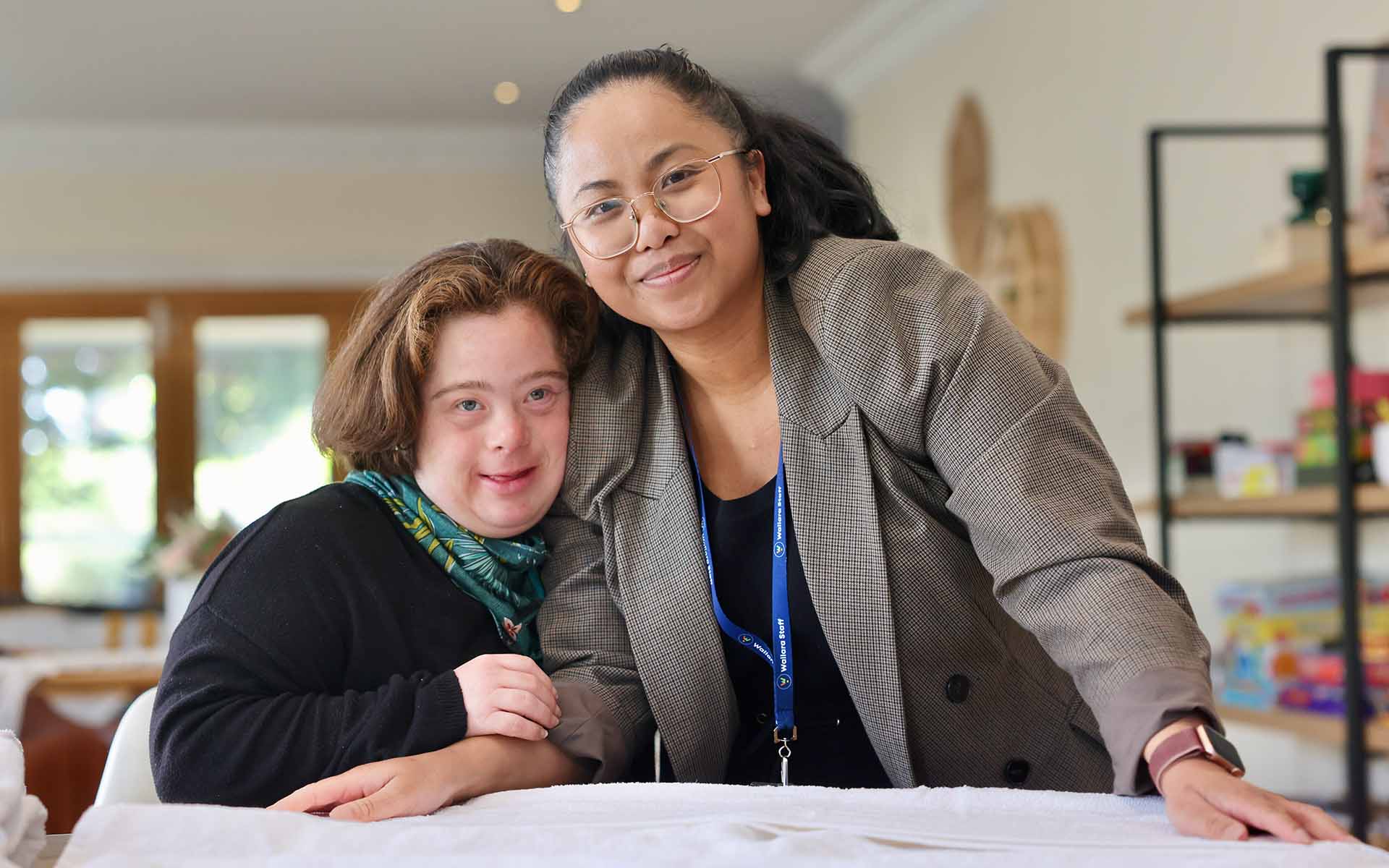 A Wallara staff member supporting a participant in a home environment.