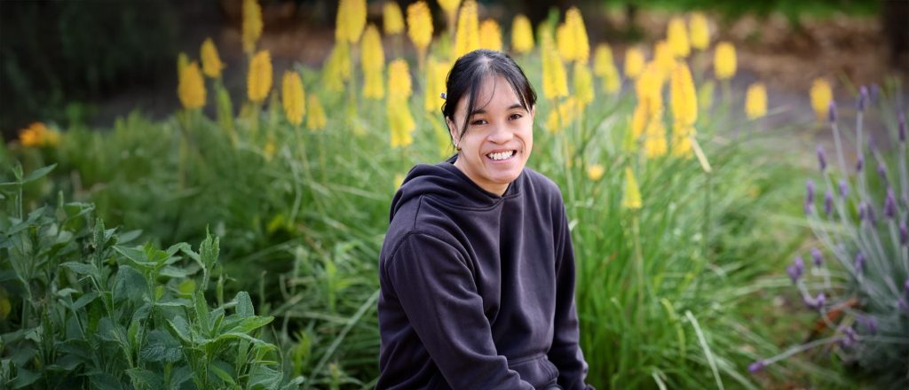 A Wallara participant sitting outdoors in a garden setting at Sages Cottage Farm.