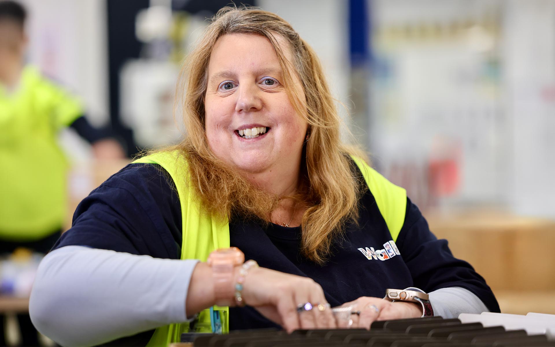 A Wallara participant works at a production table in a supported employment setting.